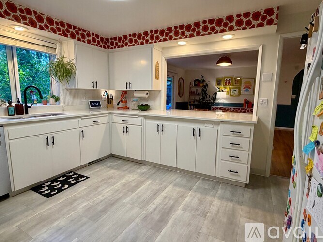 A kitchen with white cabinets and a patterned ceiling.