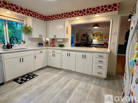 A kitchen with white cabinets and a patterned ceiling.