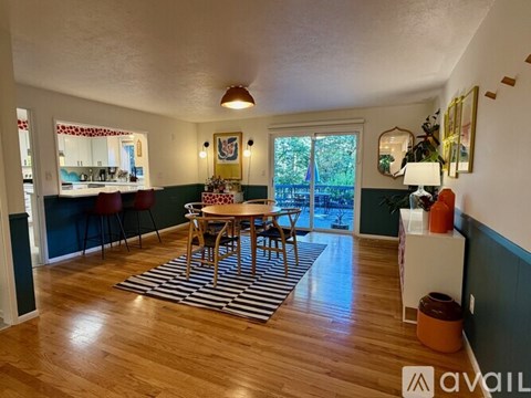 A dining room with a wooden table and chairs.