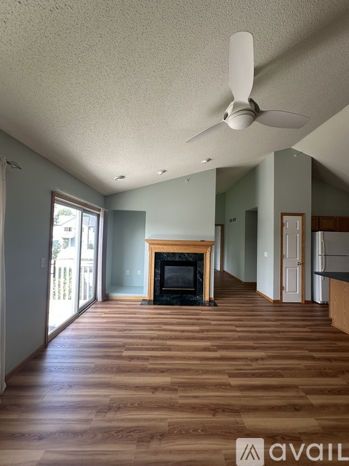 A living room with a fireplace and wood flooring.