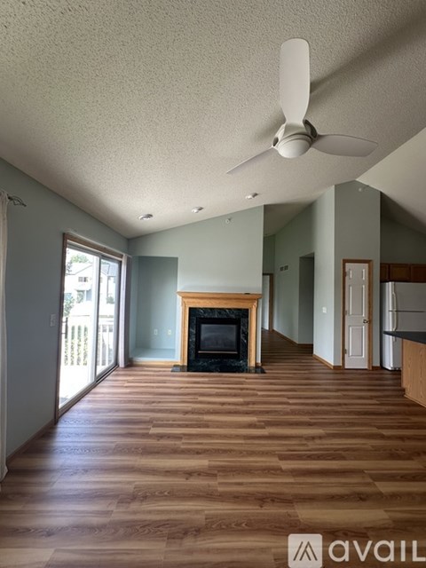 A living room with a fireplace and wood flooring.