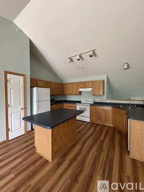A kitchen with wooden cabinets and a black countertop.