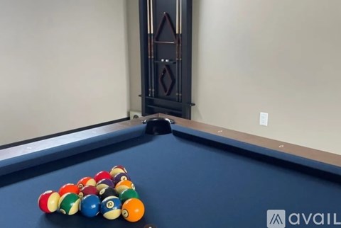 A pool table with a blue cloth and white balls.