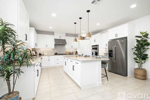 A modern kitchen with white cabinets and a central island.