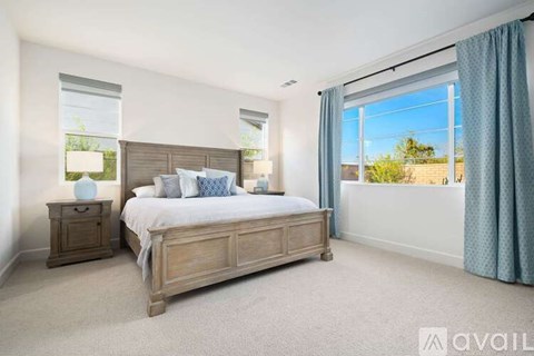 A bedroom with a large bed, nightstand, and window.