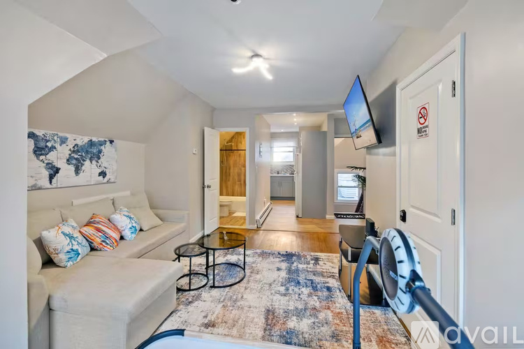 A living room with a couch, a coffee table, and a television.