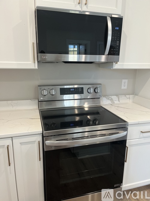 A modern kitchen with a stainless steel oven and microwave above it.