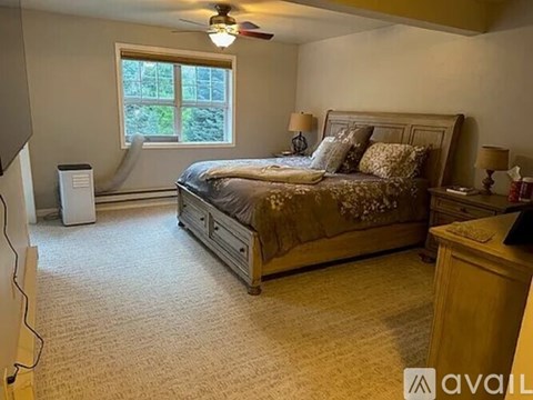 A bedroom with a large bed and a window.