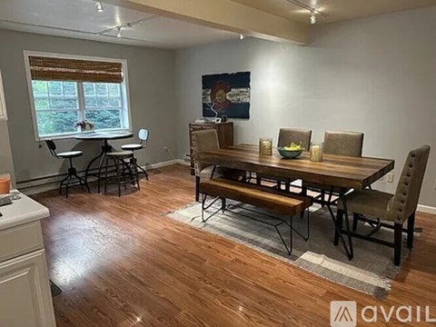 A dining room with a wooden table and chairs.