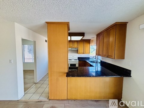 A kitchen with wooden cabinets and a black countertop.