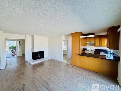 A living room with a fireplace and wooden floors.