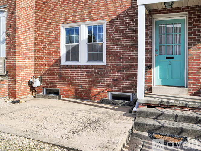 A red brick house with a blue door and a white window.