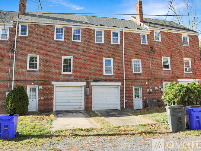 A red brick building with two white garage doors.