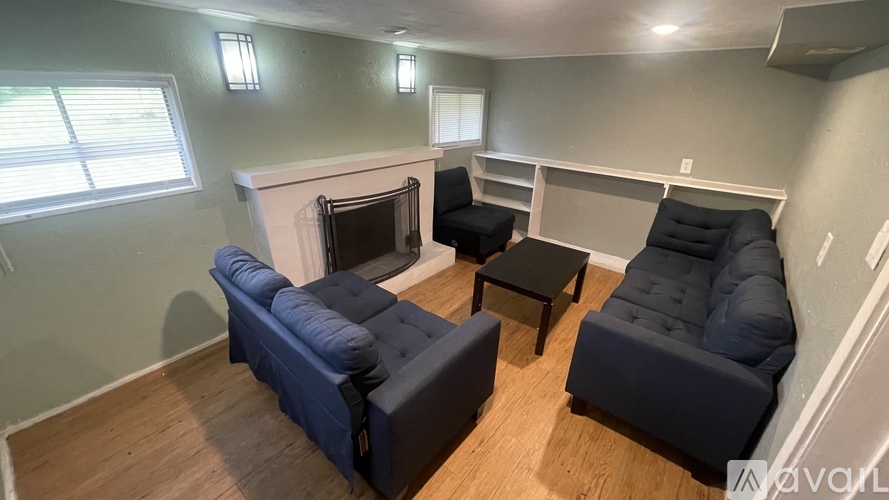 A living room with a fireplace and two blue couches.