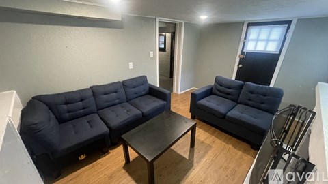 A living room with a black sofa and a black coffee table.
