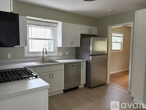 A kitchen with white cabinets and a black stove top.