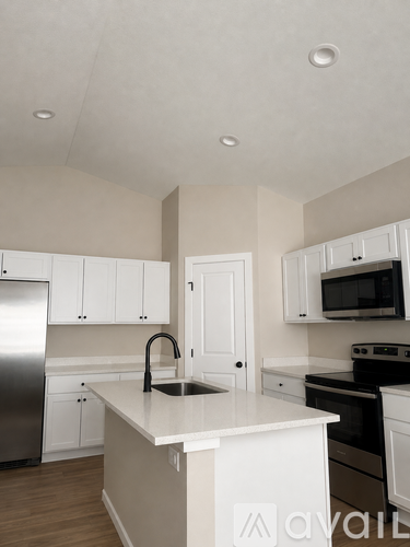 A kitchen with white cabinets and a white island.