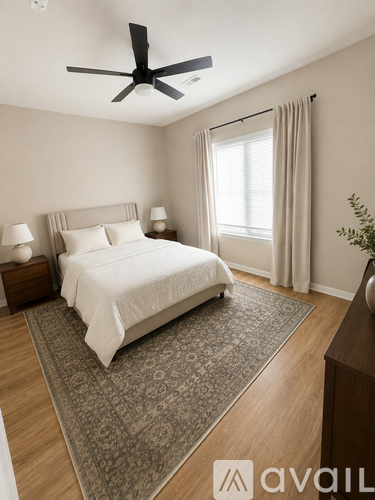 A bedroom with a large bed and a ceiling fan.
