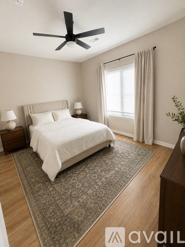 A bedroom with a large bed and a ceiling fan.