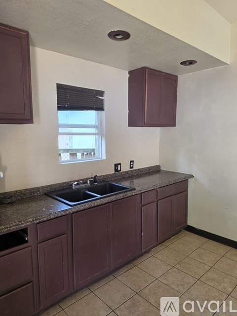 A kitchen with brown cabinets and a granite countertop.