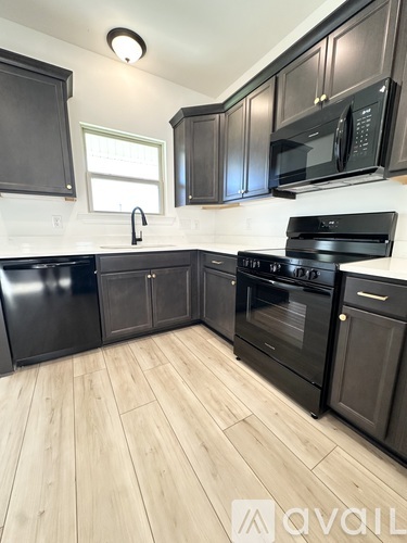 A kitchen with black appliances and cabinets.