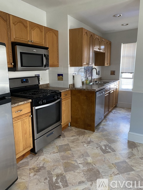 A kitchen with wooden cabinets and a black stove top oven.