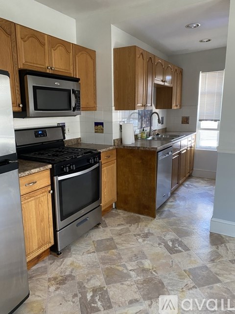 A kitchen with wooden cabinets and a black stove top oven.