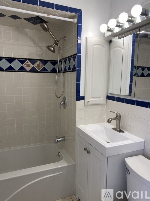 A bathroom with a white tub, sink, and toilet.