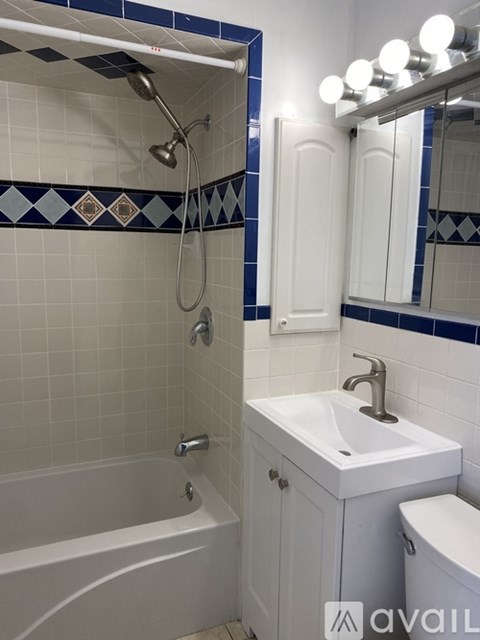 A bathroom with a white tub, sink, and toilet.
