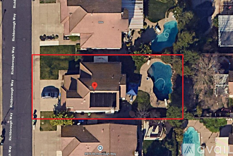 A bird's eye view of a neighborhood with a red square highlighting a house with a pool.