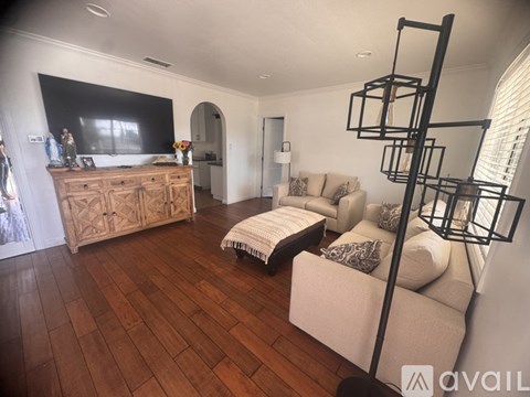 A living room with a white couch and a wooden floor.
