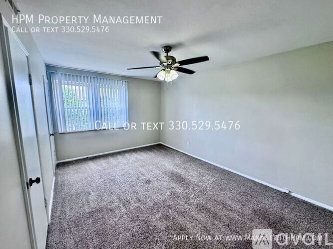 A room with a carpeted floor and a ceiling fan, managed by HPM Property Management.