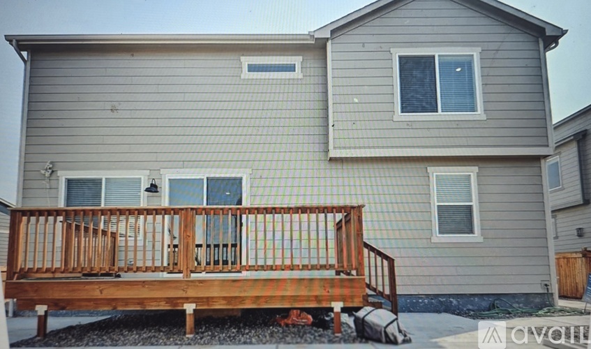 A house with a grey siding and a wooden deck.