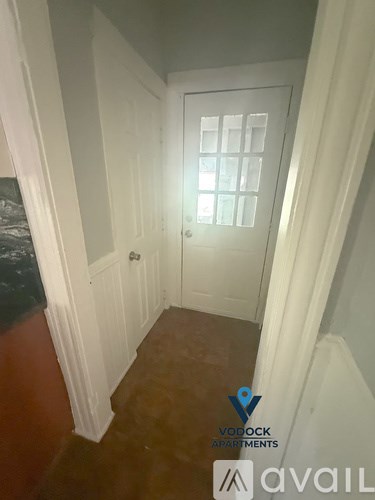 A hallway with a door and a Vodroom Apartments logo.