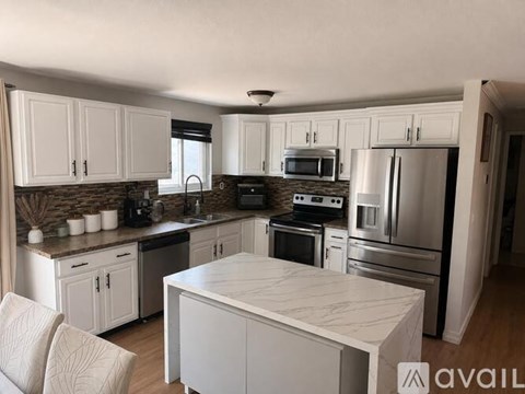A kitchen with white cabinets and stainless steel appliances.