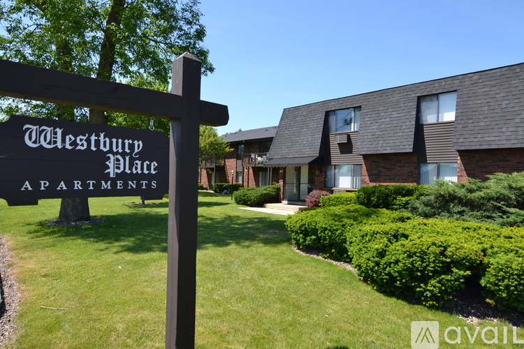 A sign for Westbury Place Apartments stands in front of a building.