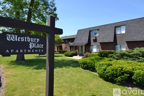 A sign for Westbury Place Apartments stands in front of a building.