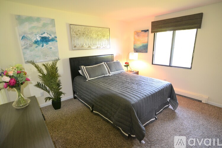A bedroom with a large bed and a painting on the wall.