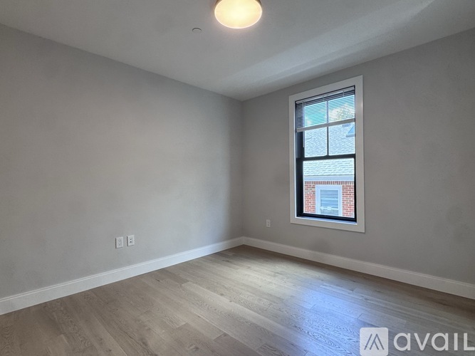 A room with a window and wooden flooring is available for rent.