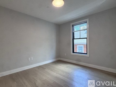 A room with a window and wooden flooring is available for rent.