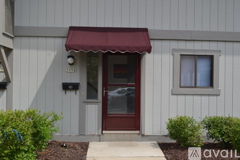 A building with a red awning and a door with a glass window.