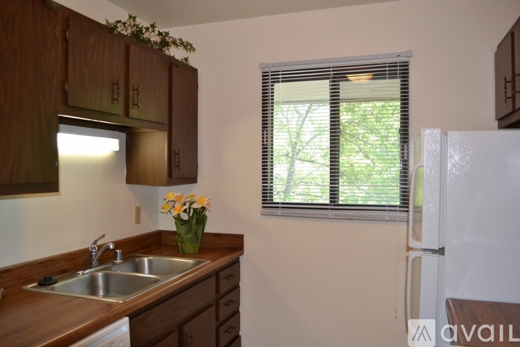 A kitchen with wooden cabinets and a white fridge.
