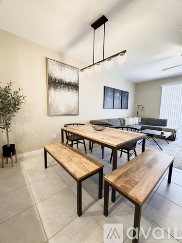 A modern dining room with a wooden table and benches.