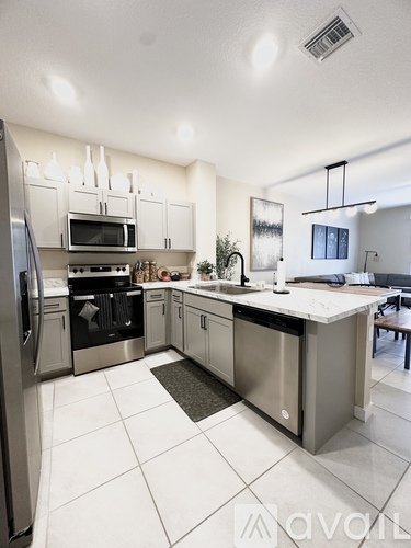 A modern kitchen with stainless steel appliances and white cabinets.