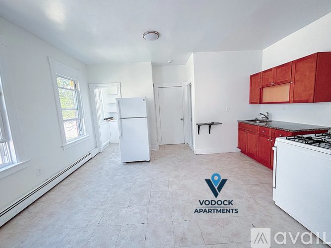 A white fridge in a kitchen with a logo for Vodock Apartments.
