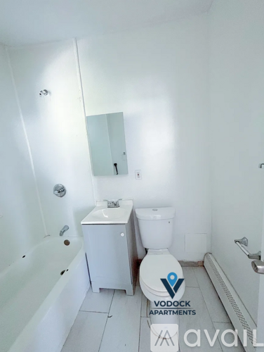 A white bathroom with a toilet, sink, and bathtub.