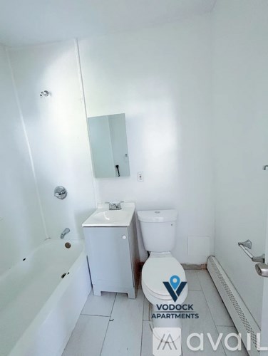 A white bathroom with a toilet, sink, and bathtub.