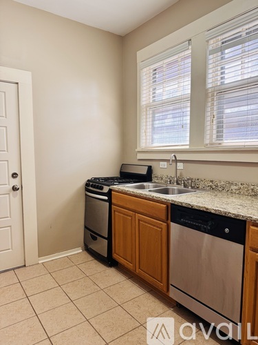 A kitchen with a sink, dishwasher, and a window.