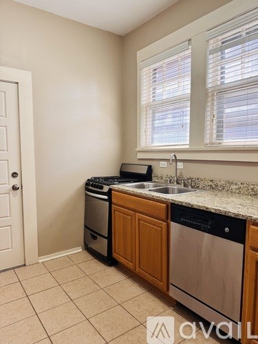 A kitchen with a sink, dishwasher, and a window.