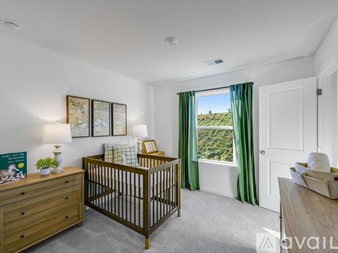A baby's room with a crib, dresser, and window with green curtains.